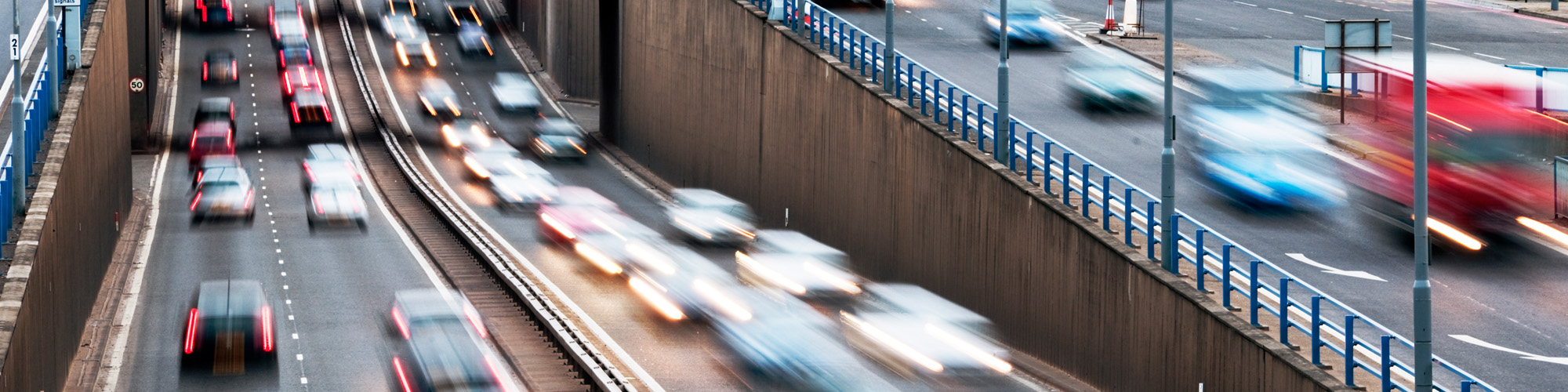A blurred image of a number of cars travelling along a road